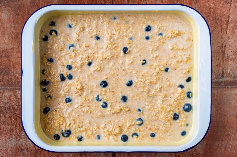 baking dish containing a milky oat and blueberry mix.