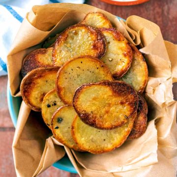 Garlic Potato Chips in a paper lined bowl.