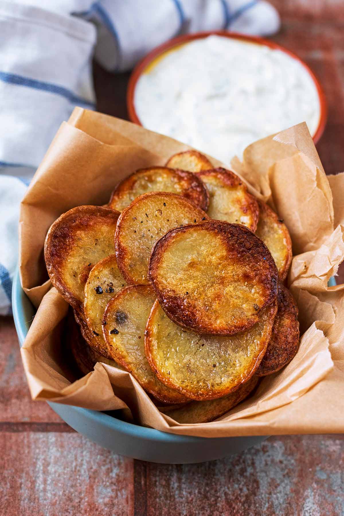 A bowl of crisps and a small dish of creamy dip.
