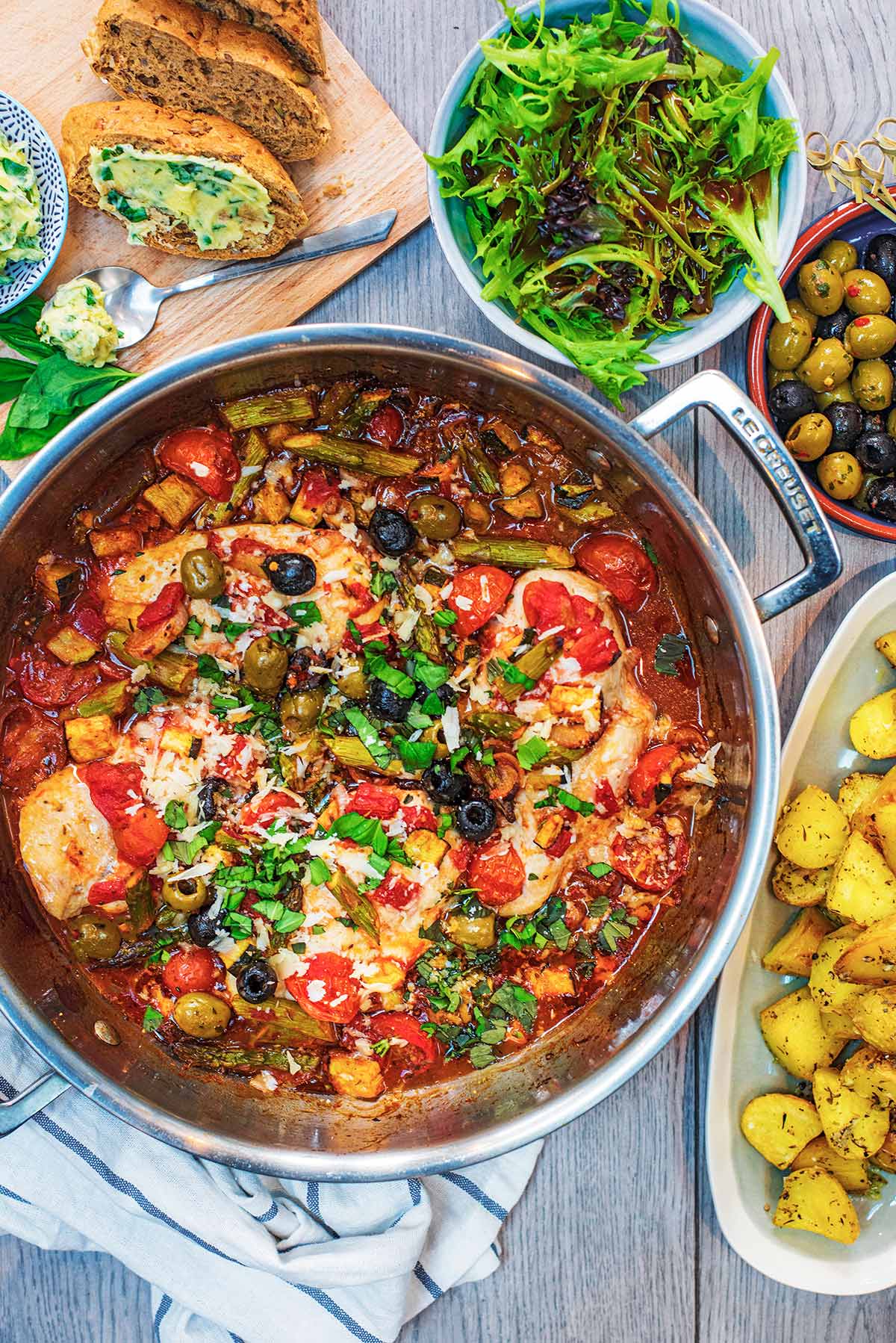 A large silver dish pan containing Italian Chicken in a vegetable sauce.
