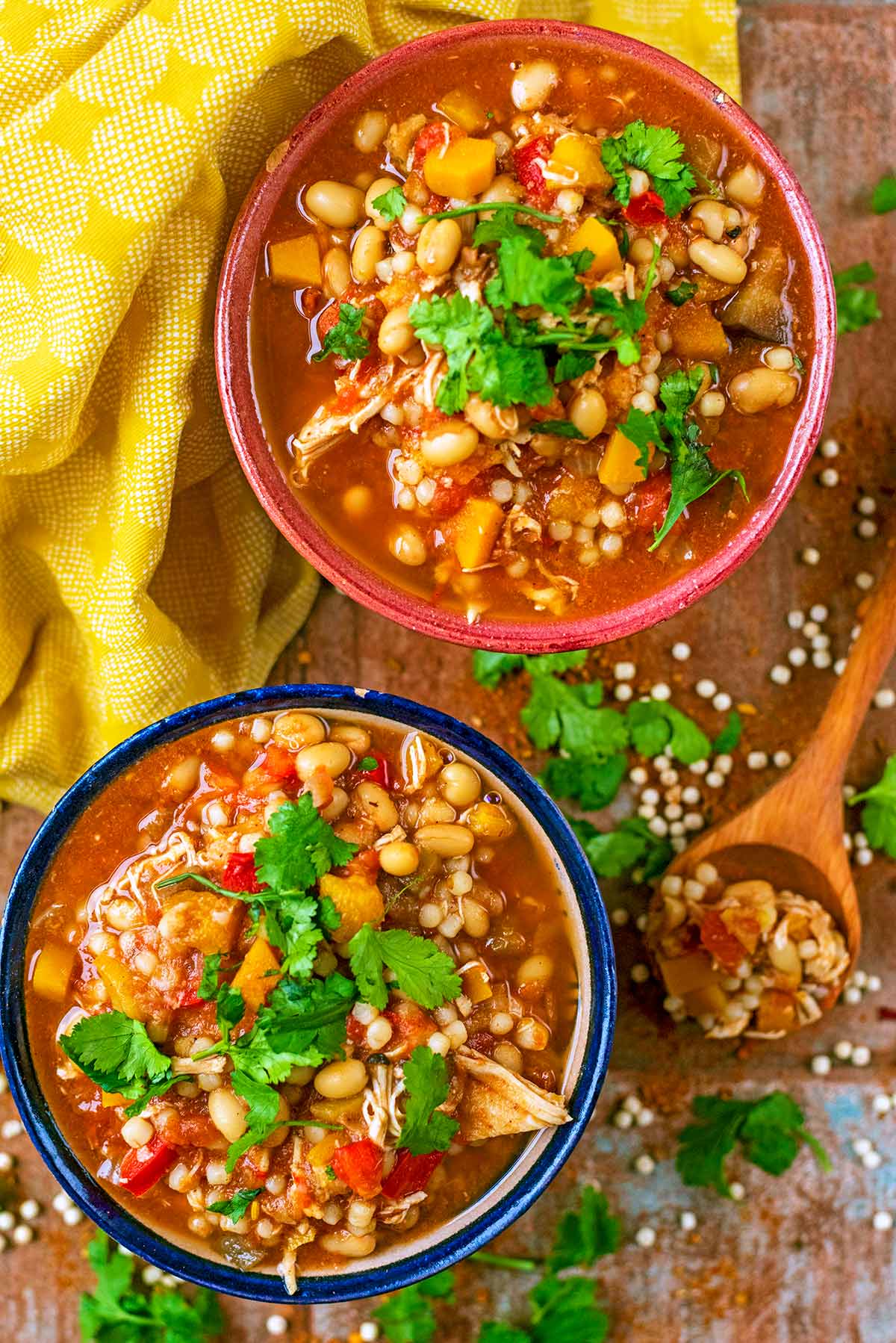 Two bowls of moroccan chicken stew next to a yellow towel.