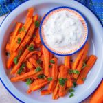 A plate of carrot fries with a small dish of dip.
