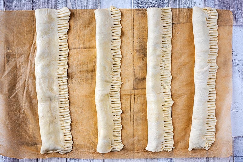 Long lengths of pastry, folded over sausage meat and crimped