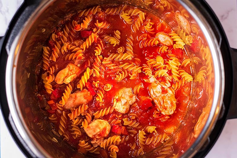 An instant pot bowl containing pasta in a tomato sauce.