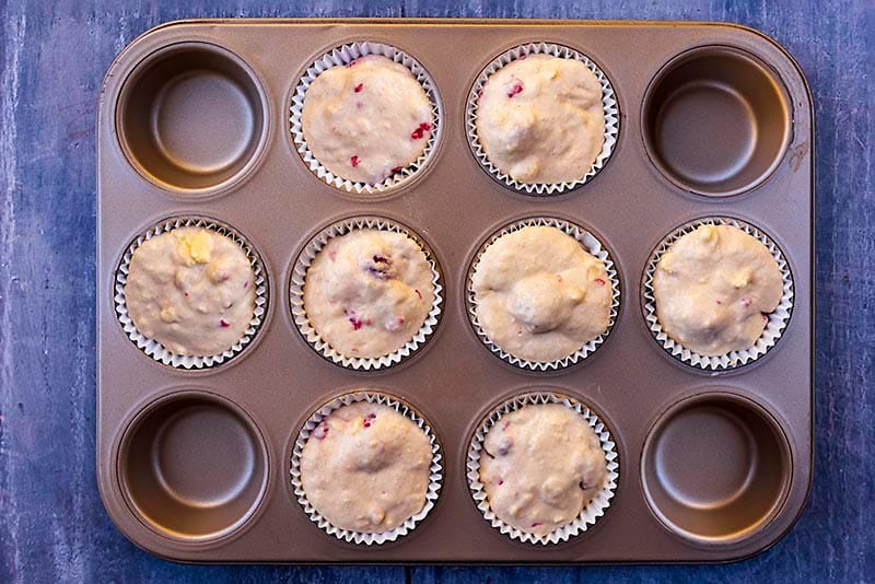 Muffin mixture in eight paper cases in a muffin tin