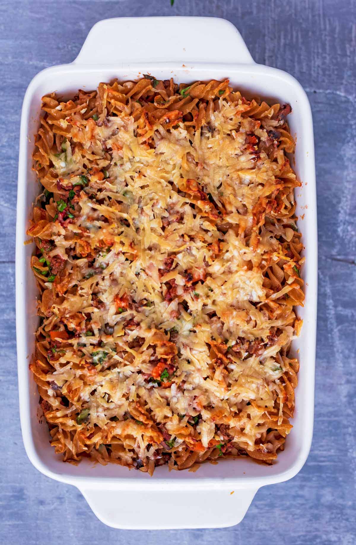 Bolognese pasta bake in a baking dish covered in melted cheese.