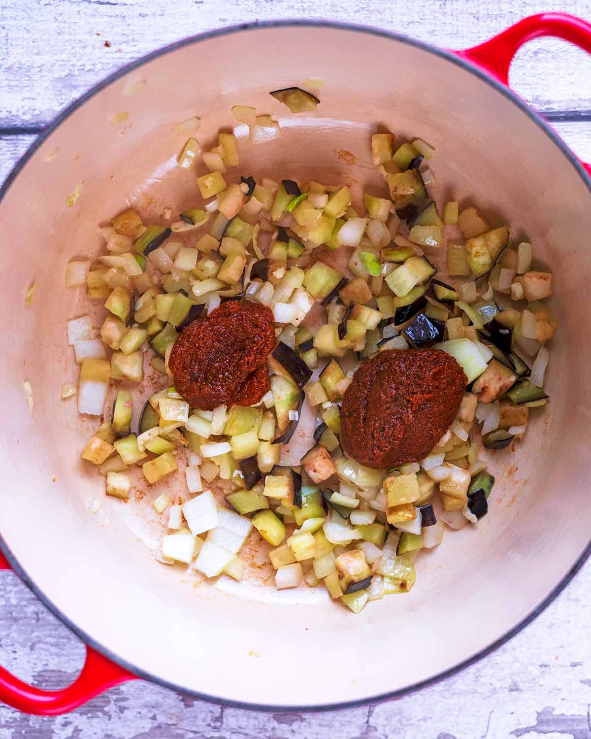 Shallots, garlic and eggplant in a large pan with some curry paste.
