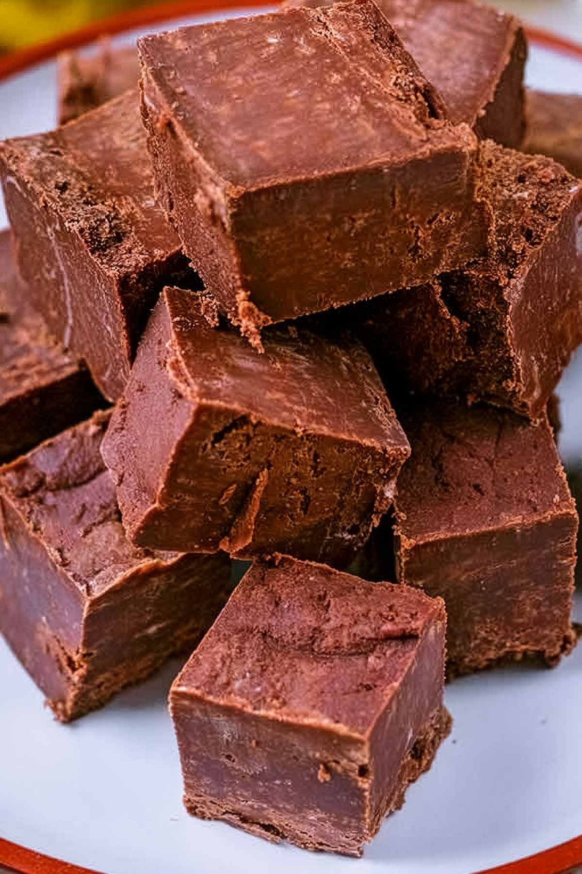 Cubes of chocolate fudge stacked on a plate.