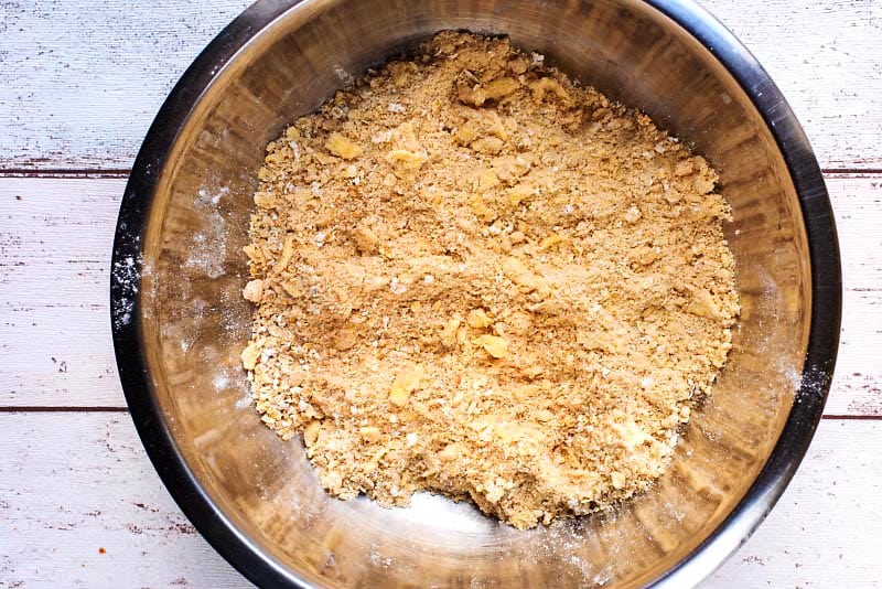 A mixing bowl with a crumble mixture in it.