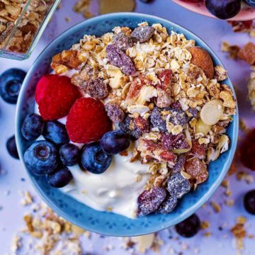 A bowl of yogurt topped with homemade muesli and berries.