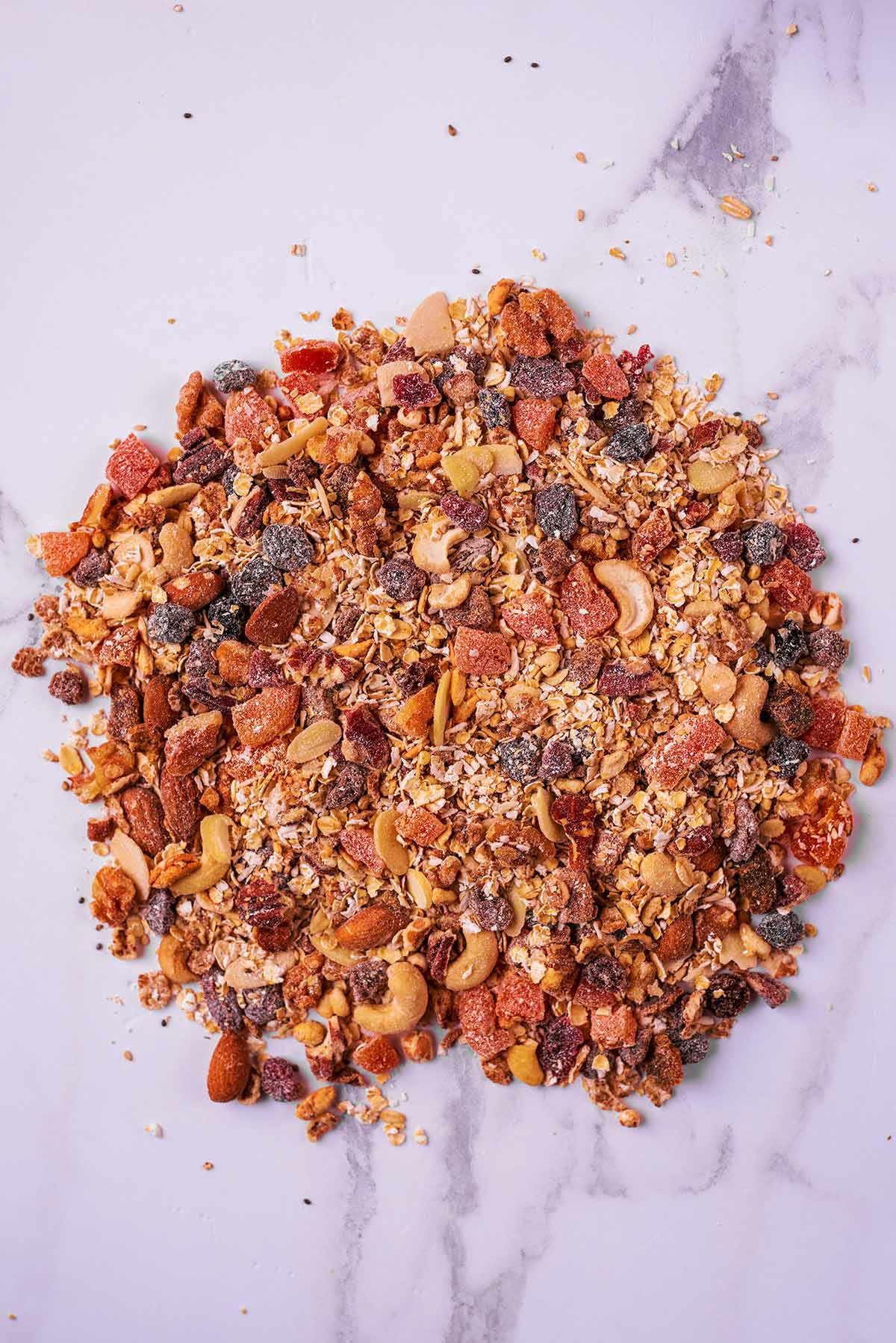 Homemade muesli all mixed together on a marble surface.