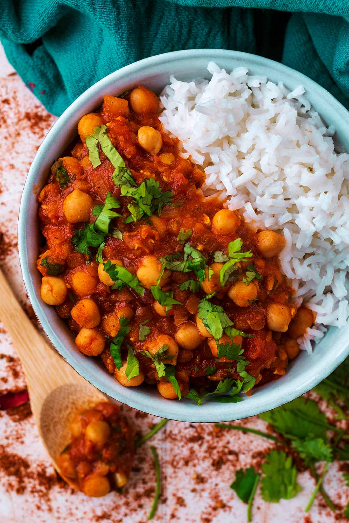 A bowl of Moroccan Chickpea Stew and rice next to a blue towel.