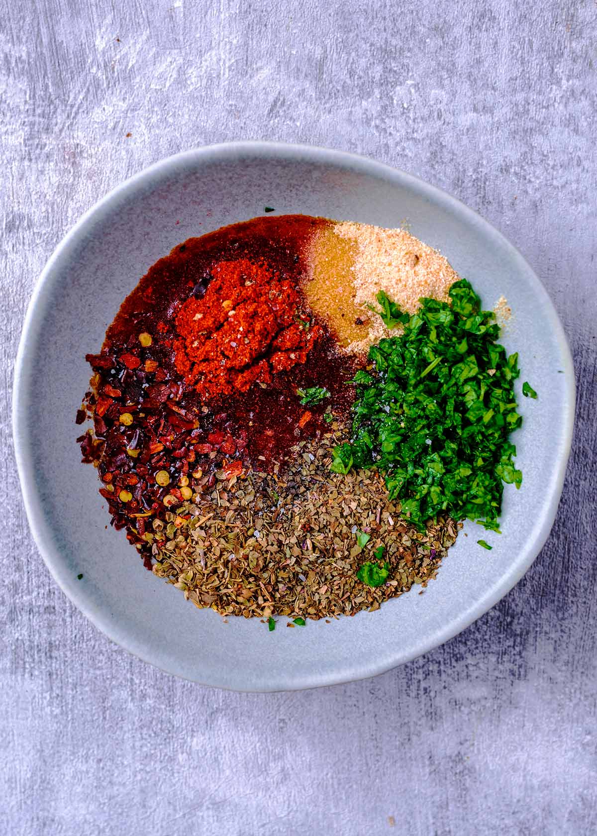 Oil, herbs and spices in a small bowl.