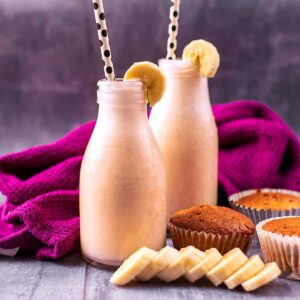 Two bottles of easy banana milk in front of a purple towel