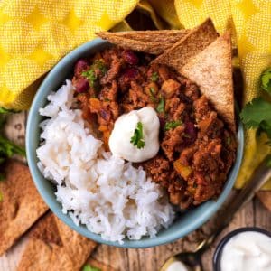A bowl of chilli con carne and rice with a dollop of sour cream on top