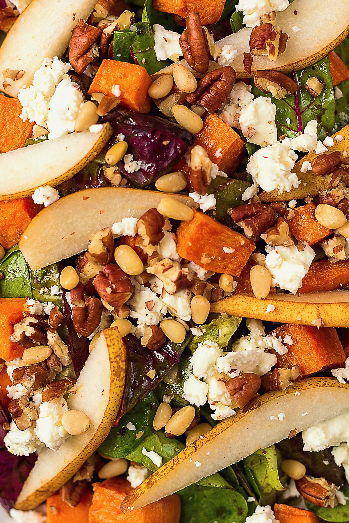 Salad leaves mixed with pear slices, sweet potato cubes and pine nuts.