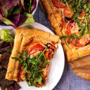 Tomato puff pastry tart topped with arugula