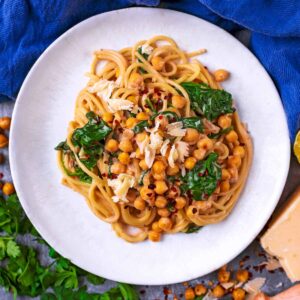 Easy Chickpea Pasta on a plate next to some Parmesan cheese.