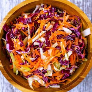 Healthy coleslaw in a round wooden bowl.