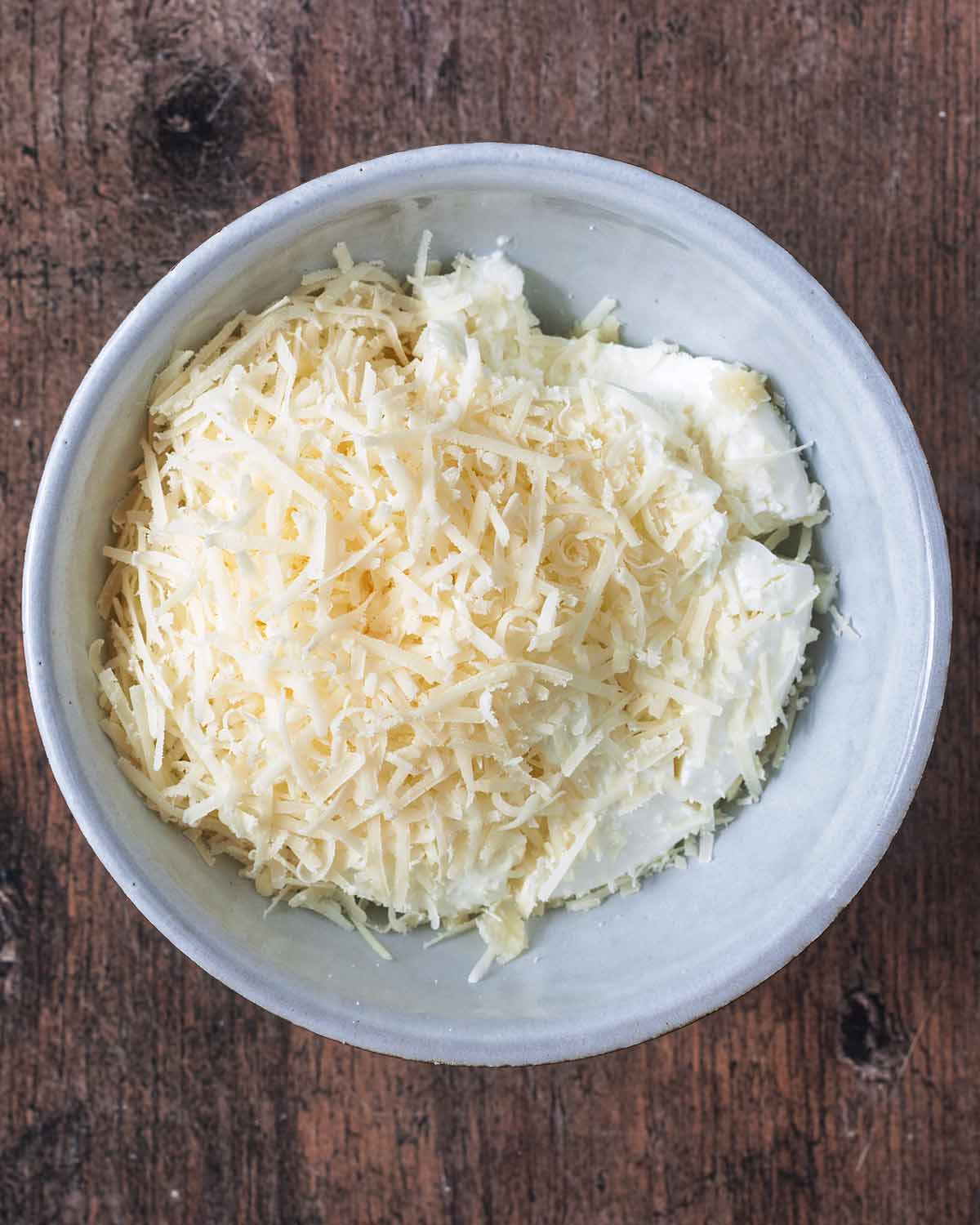 Ricotta and grated parmesan in a small bowl.