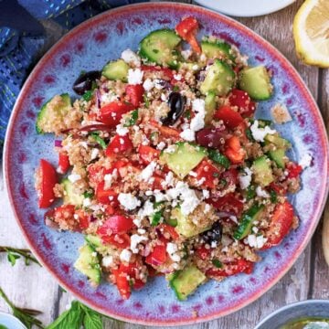Quinoa Greek Salad on a blue patterned plate.