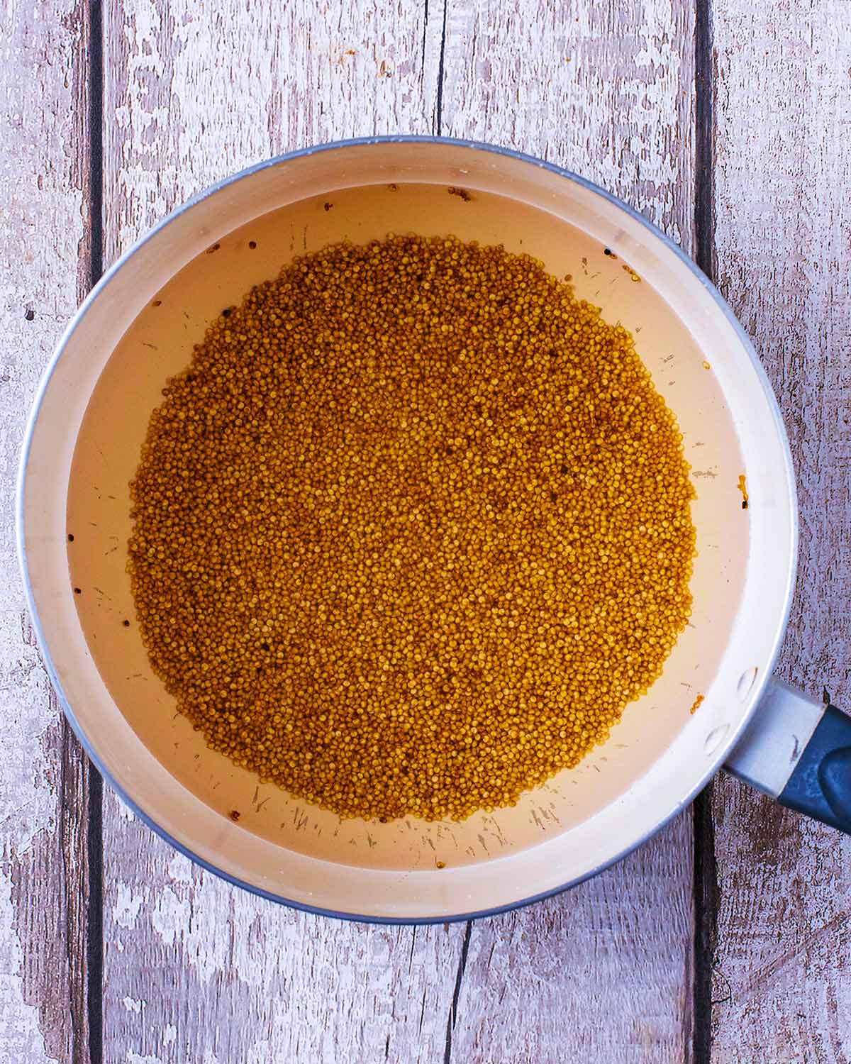A saucepan containing cooked quinoa.