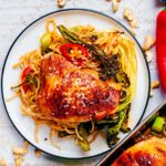 Sticky Chicken Tray Bake next to a plate of chicken and noodles.