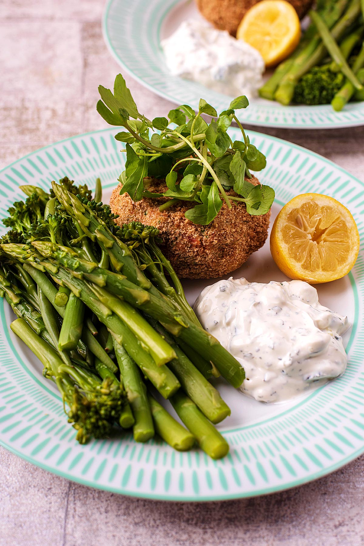 A plate of fishcake, asparagus and tzatziki.