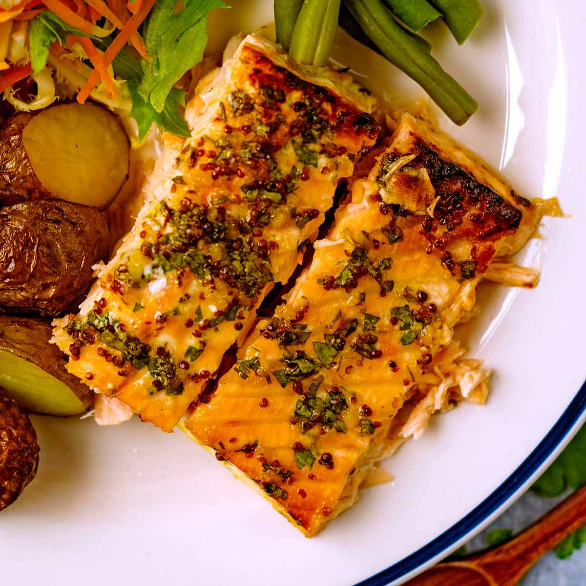 Honey Mustard Salmon on a plate with potatoes, beans and slaw.