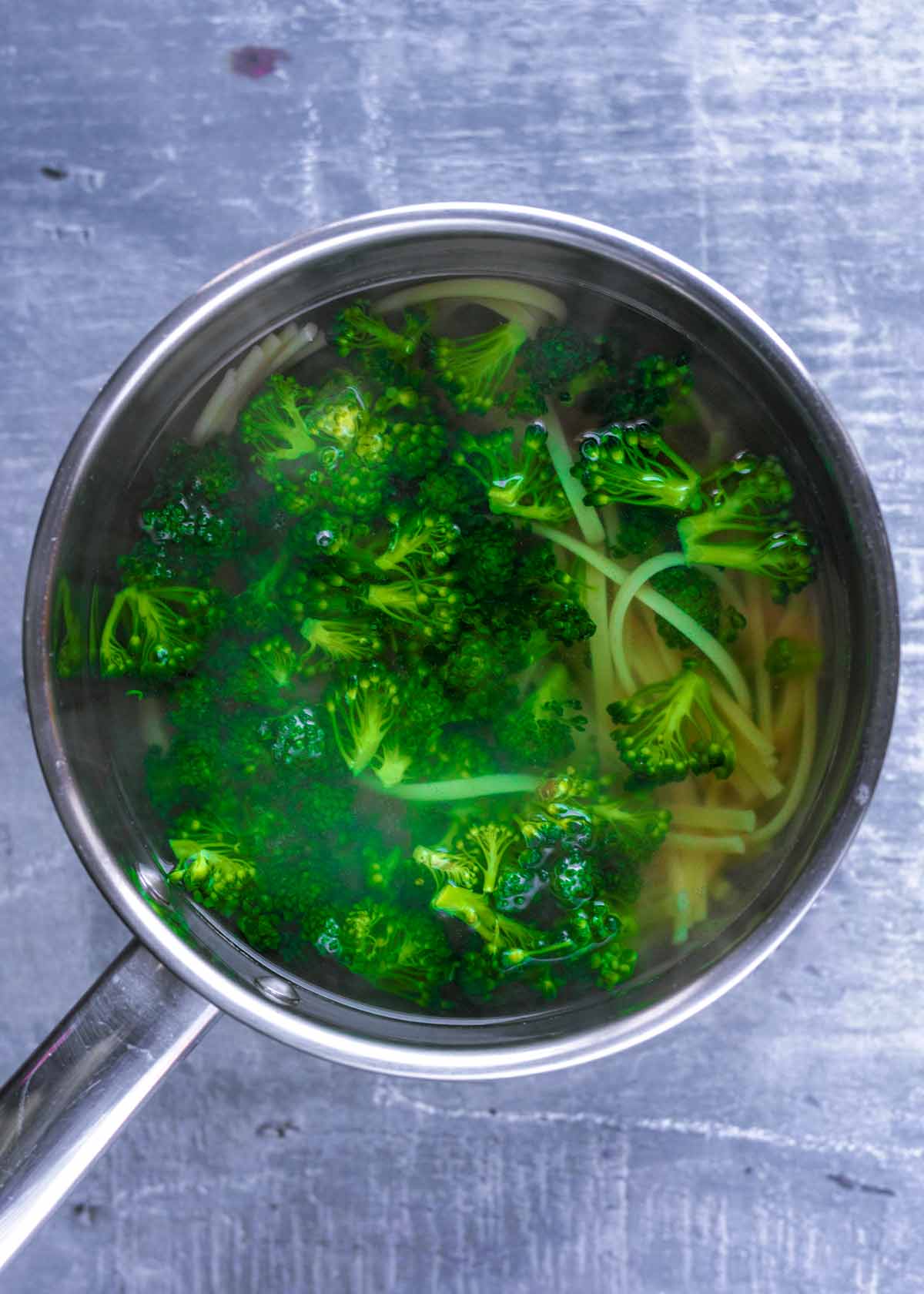 Broccoli and pasta boiling in a pan.