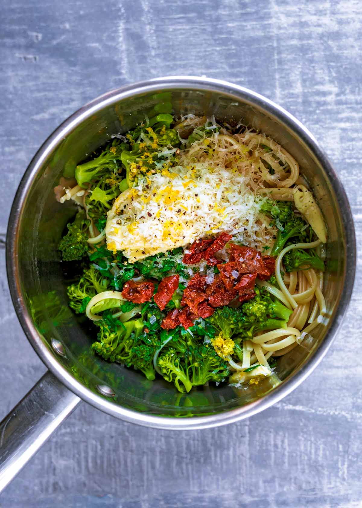 Pasta, broccoli, chopped tomatoes, cream, lemon zest and seasoning all in a stainless steel pan.