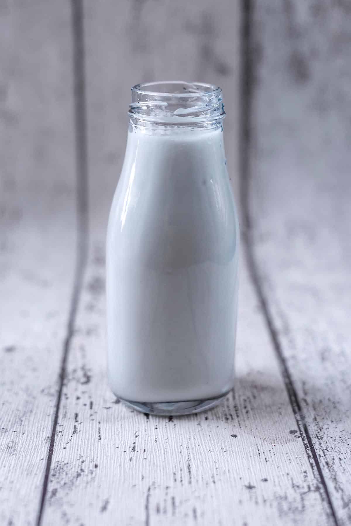 A small glass bottle full of milk.