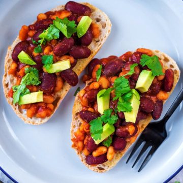 Two slices of Mexican Beans on sourdough toast, topped with avocado