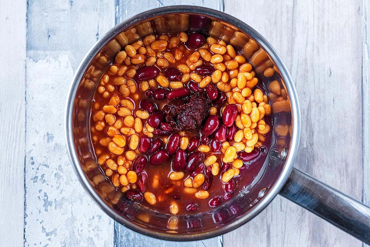 A saucepan containing baked beans. kidney beans and chipotle paste.