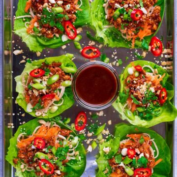 Six Asian Lettuce Wraps on a serving tray with a pot of hoisin sauce.
