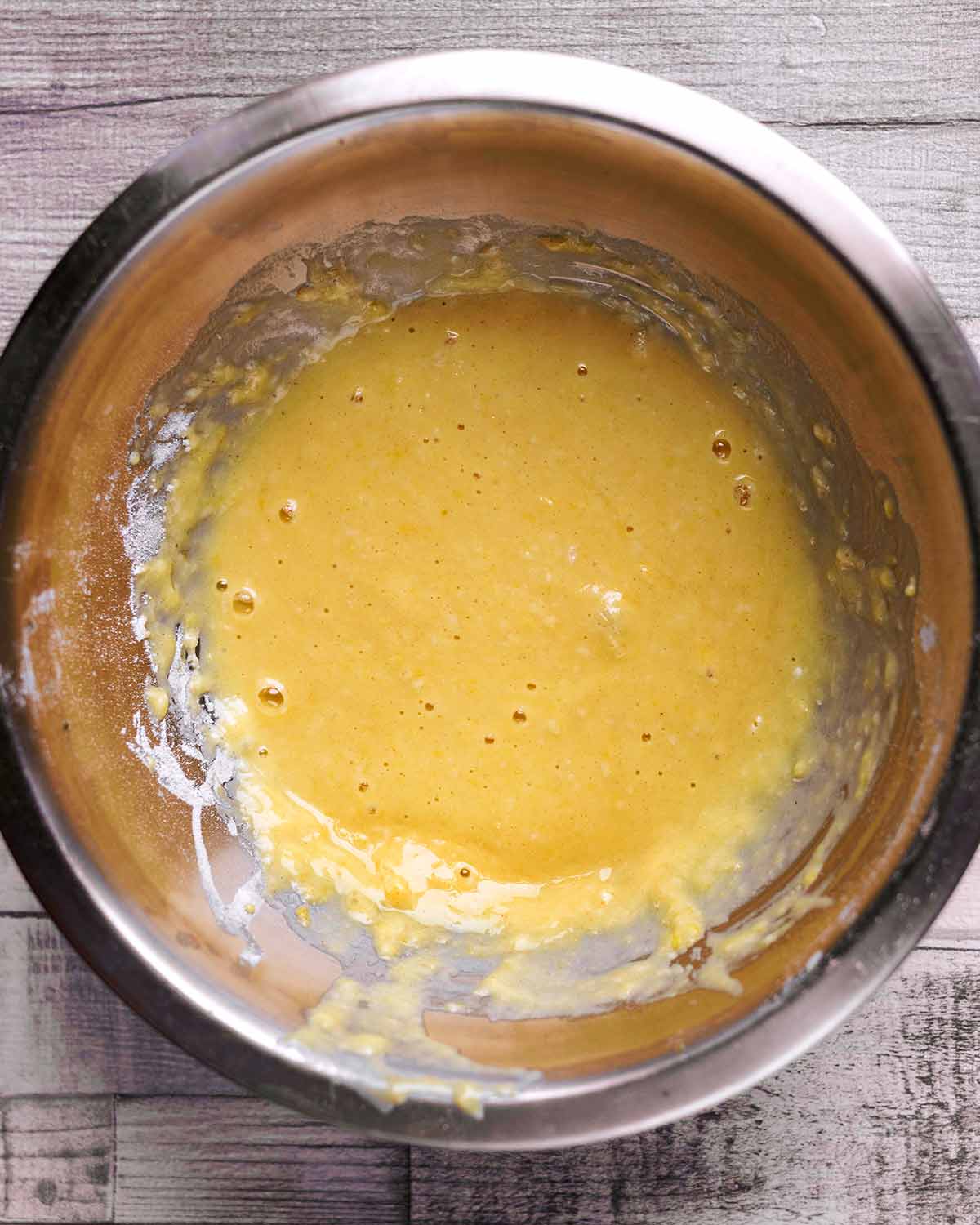 A mixing bowl containing an egg and flour batter.