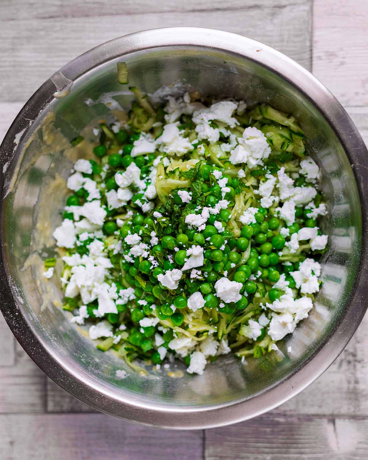 Peas, feta cheese and chopped mint added to the bowl.