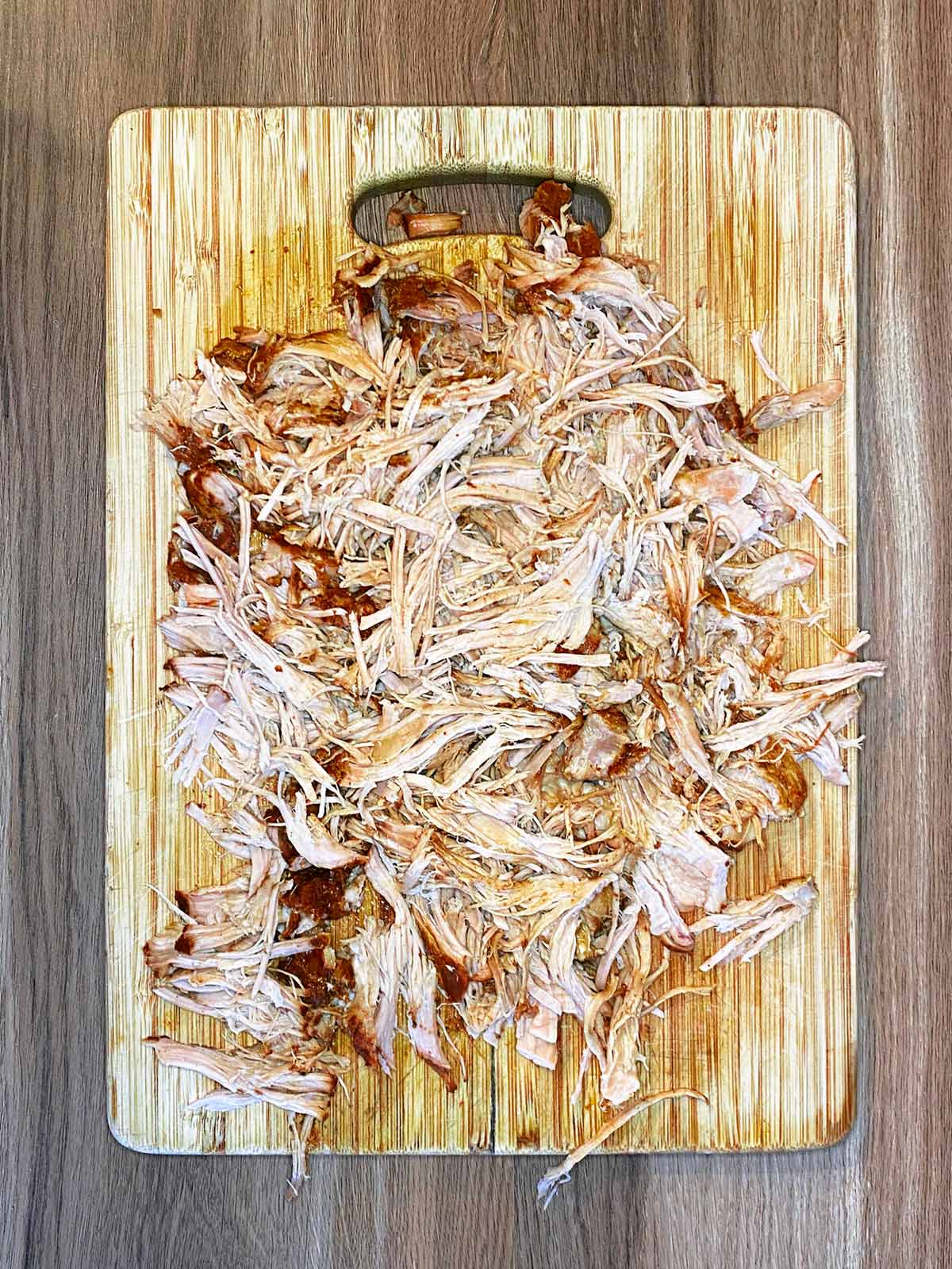 Shredded pork on a chopping board.