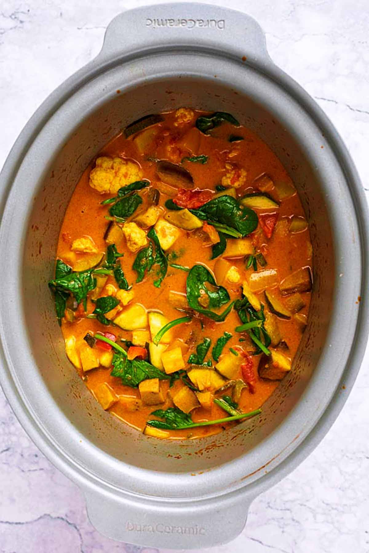 A slow cooker bowl with a vegetable curry in it.
