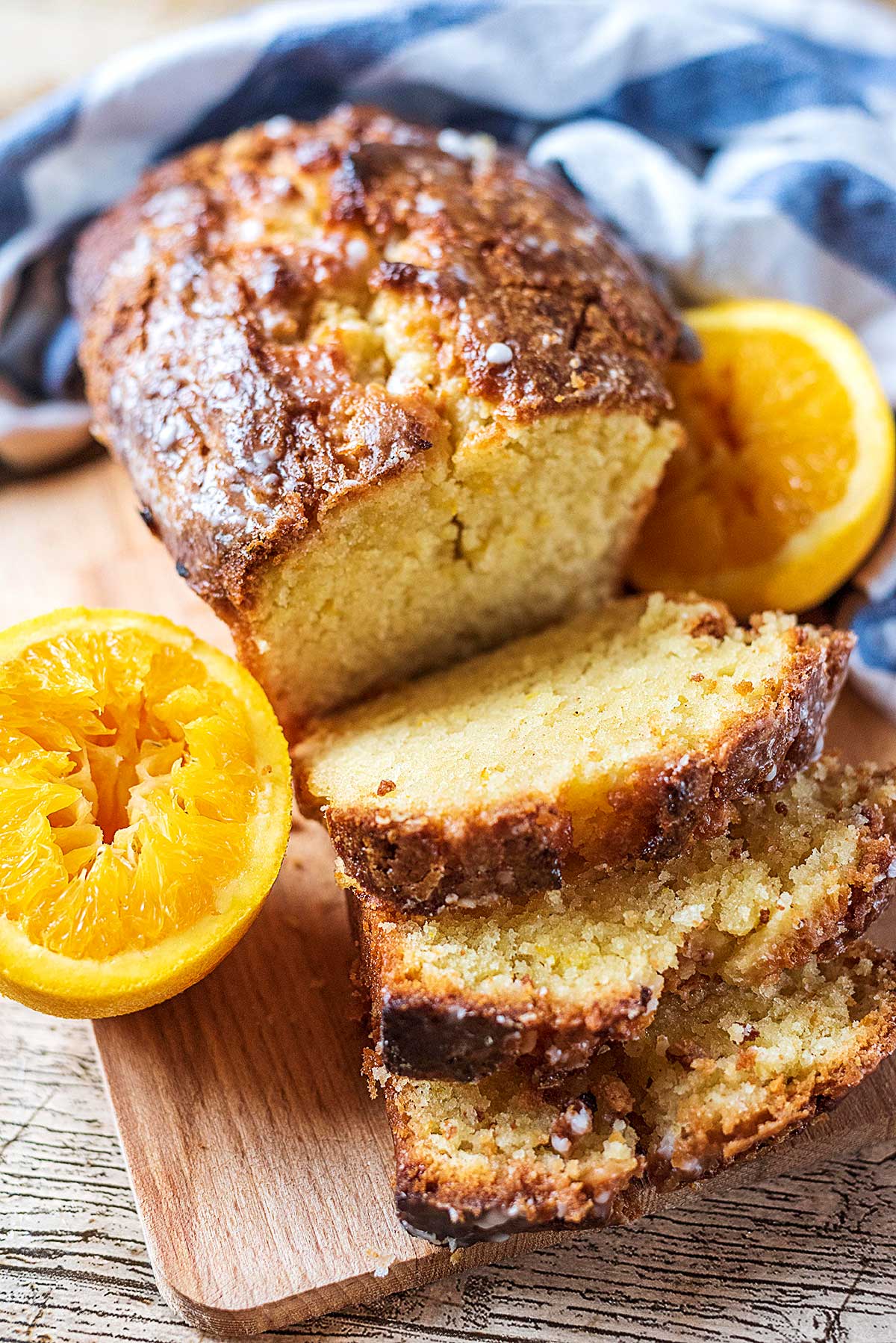 A sliced loaf cake with two orange halves either side of it.