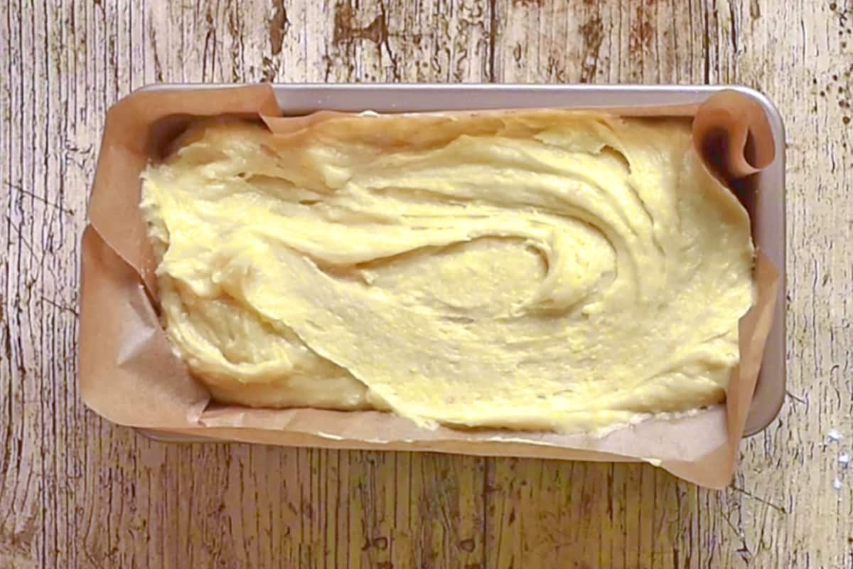 Cake batter in a lined loaf tin.
