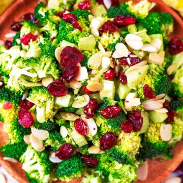 Broccoli Salad on a wooden serving plate next to a yellow towel.