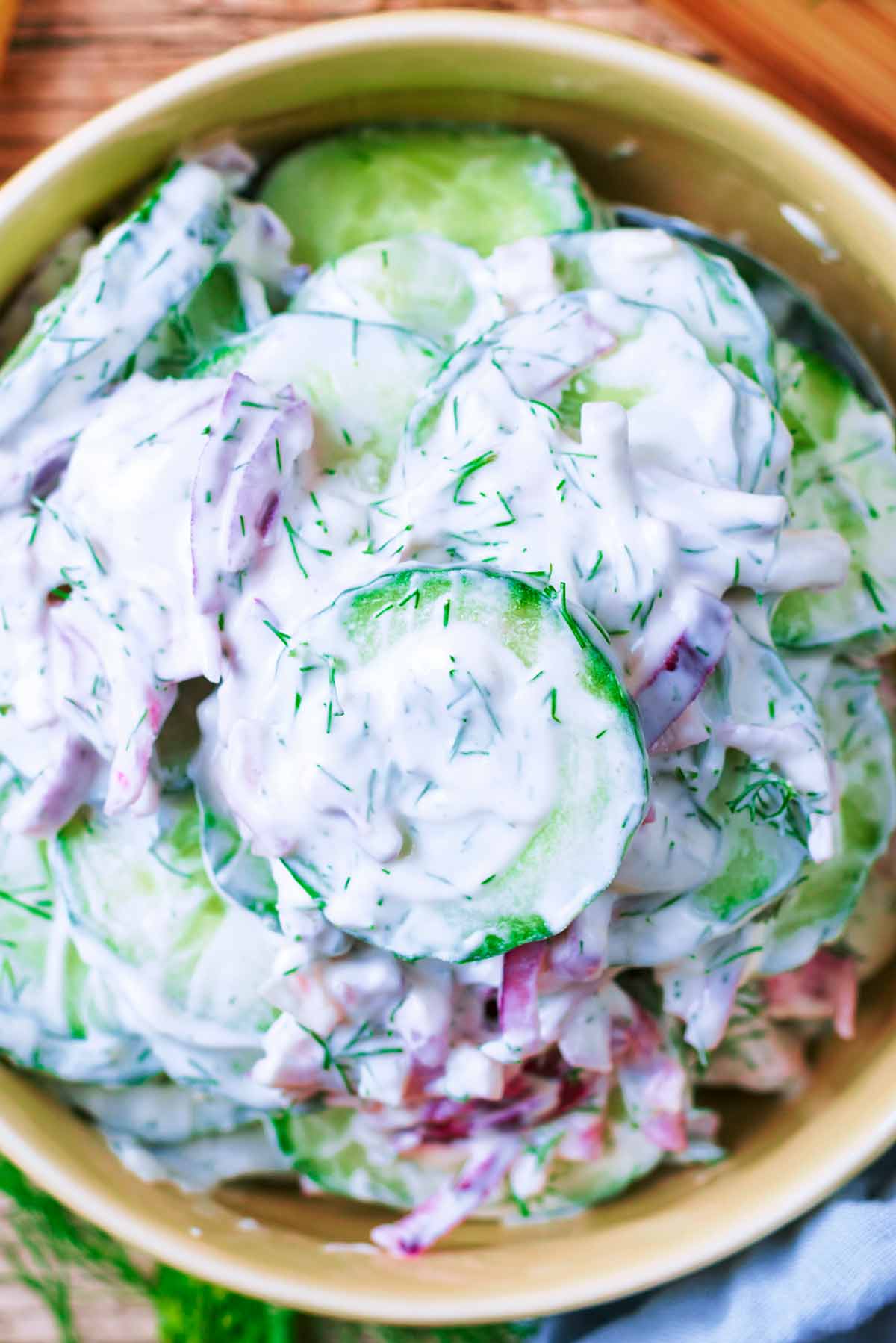Slices of cucumber dressed in a creamy sauce with chopped onions and dill.