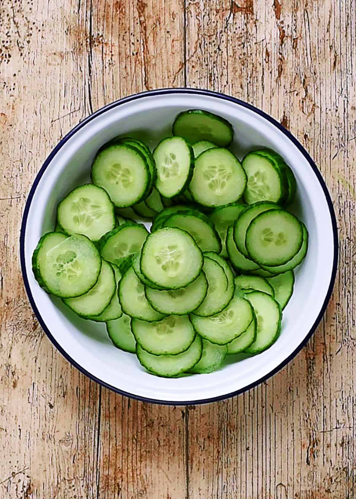 Cucumber slices in an enamel bowl.