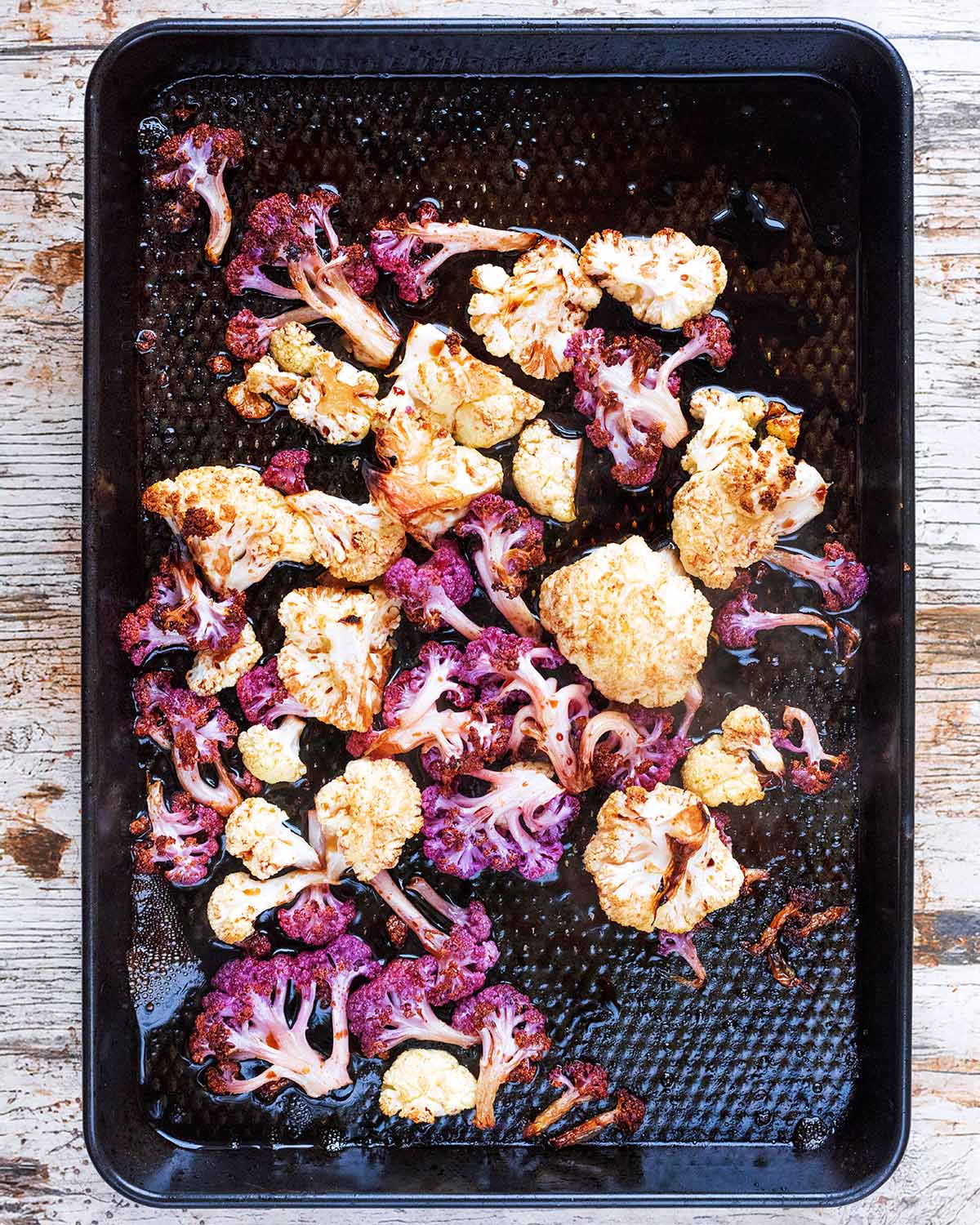 Roasted cauliflower florets on a baking tray.