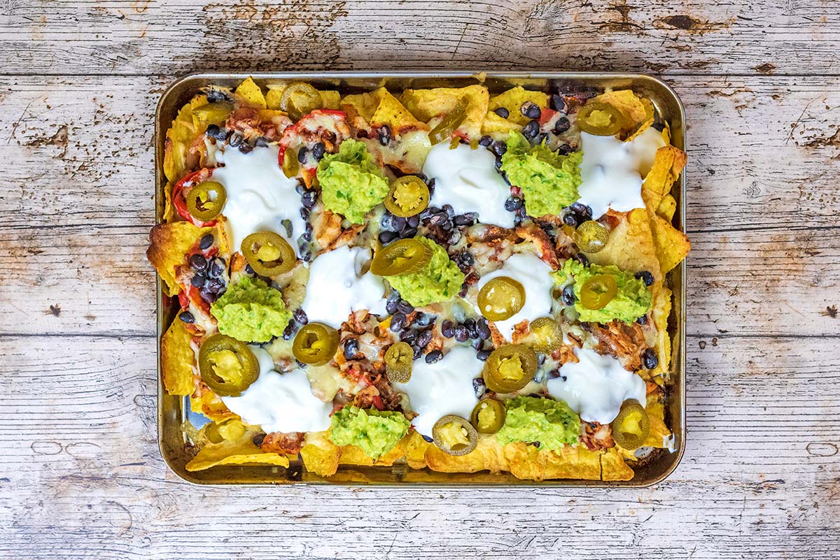 Nachos topped with sour cream, guacamole and jalapenos.