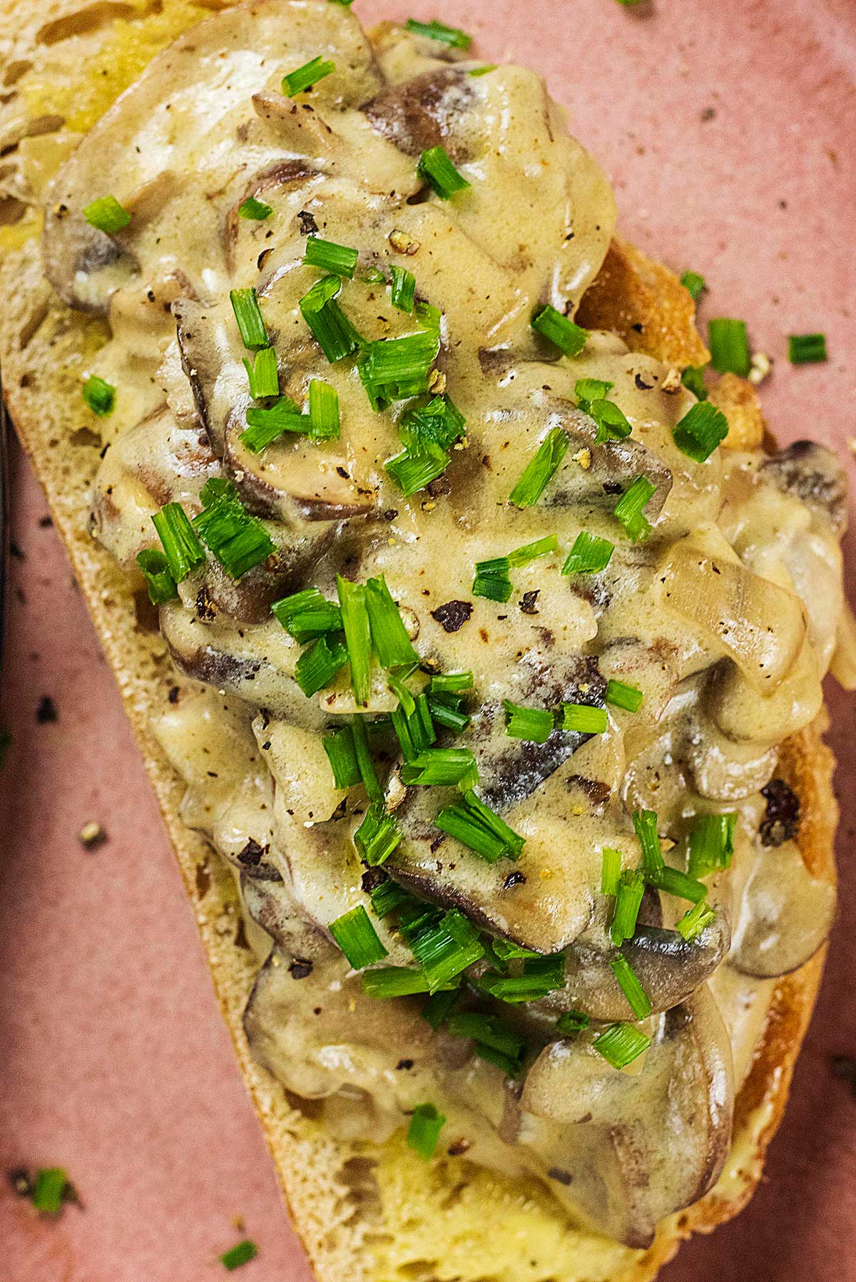 Chopped chives on top od mushrooms in a creamy sauce.