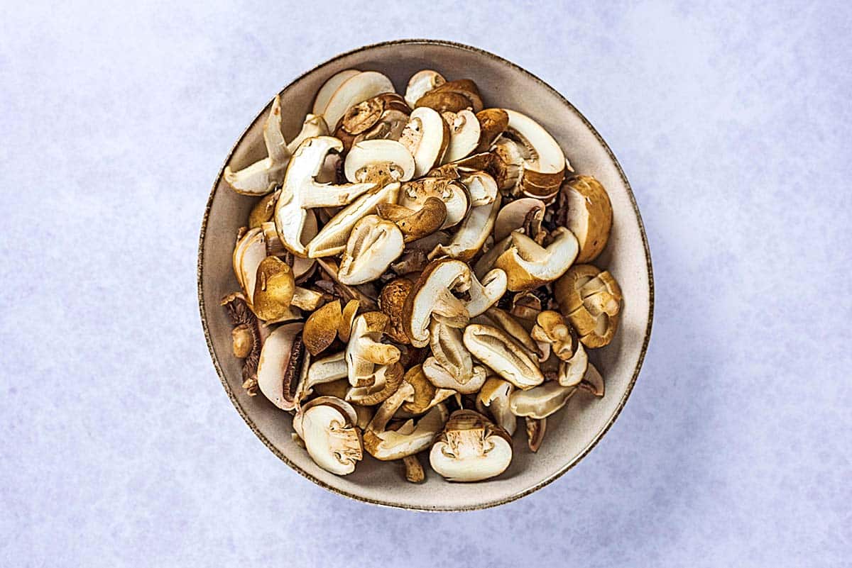 Sliced mushrooms in a large bowl.