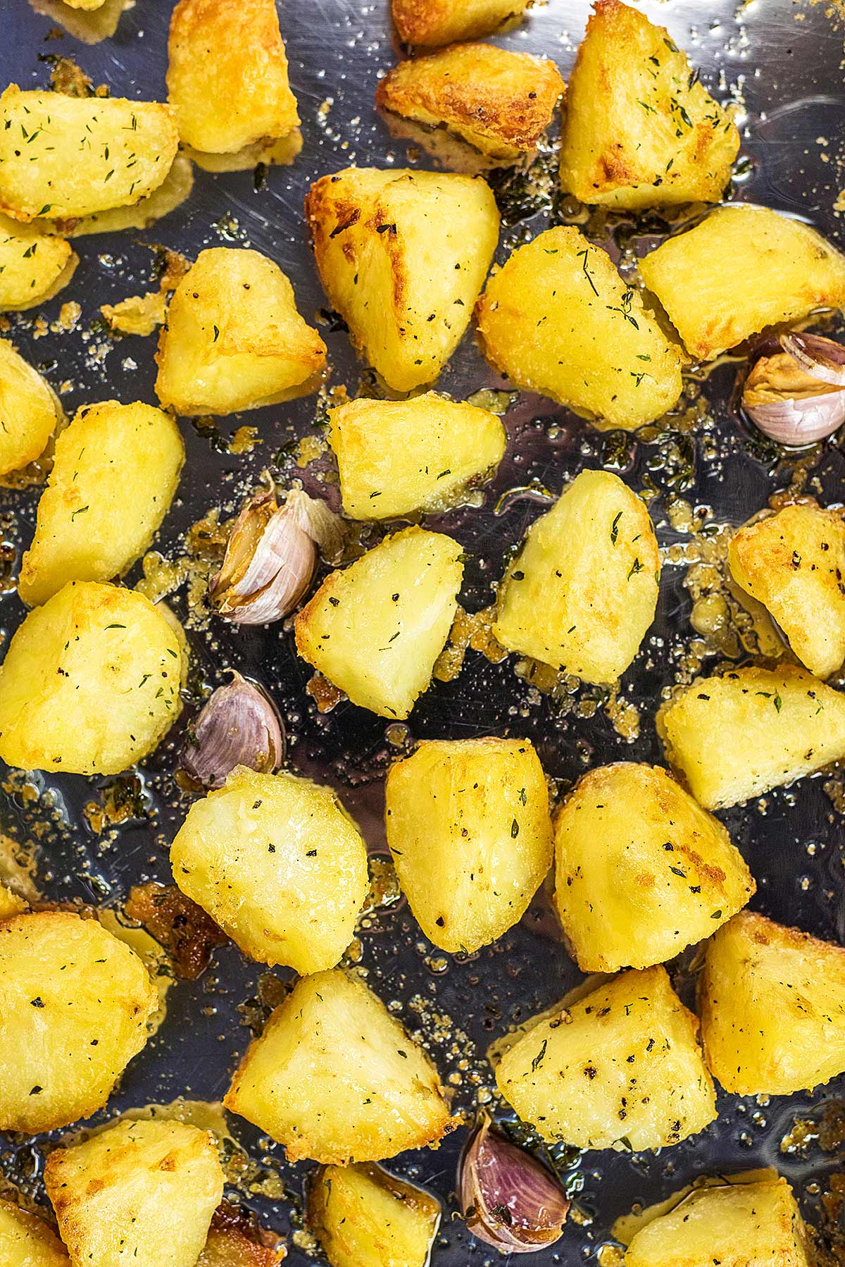 crispy roast potatoes spread over a baking tray.