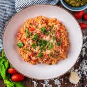 Easy Tomato Baked Risotto in a large bowl topped with chopped herbs.